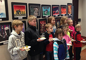 A group of children shows off their artworks.