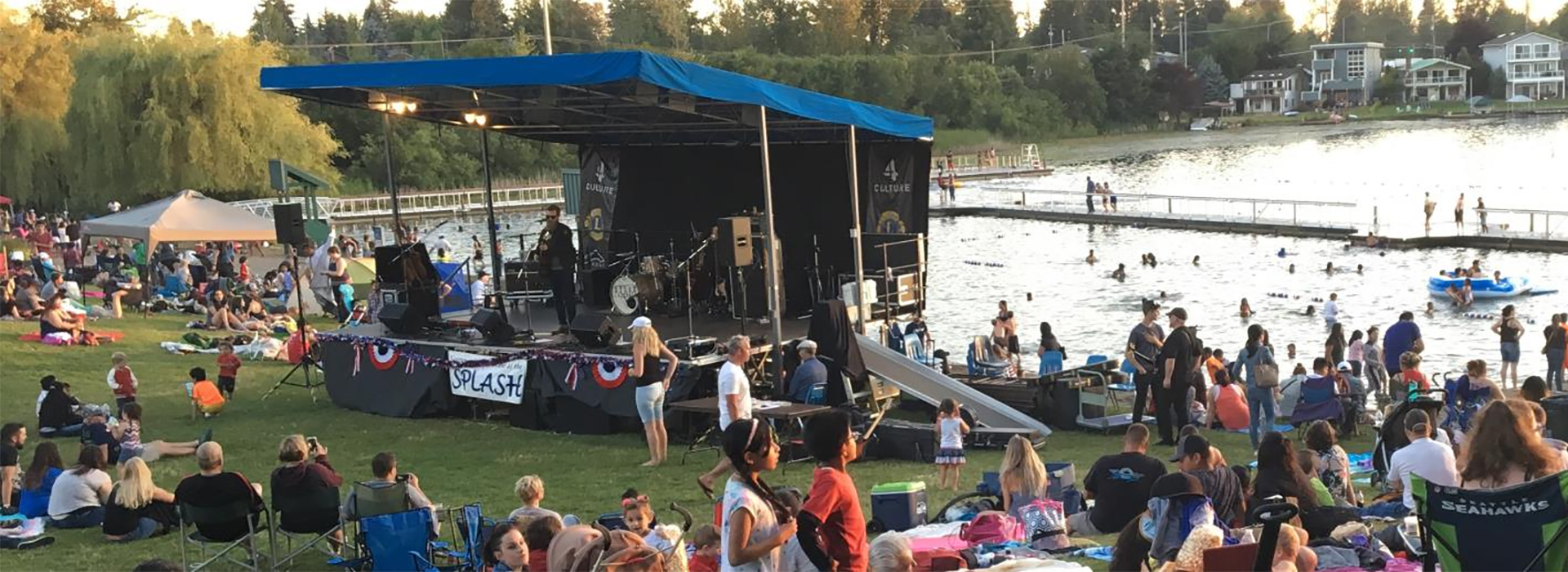 A crowd gathered on the lawn over looking the main stage by the lake.