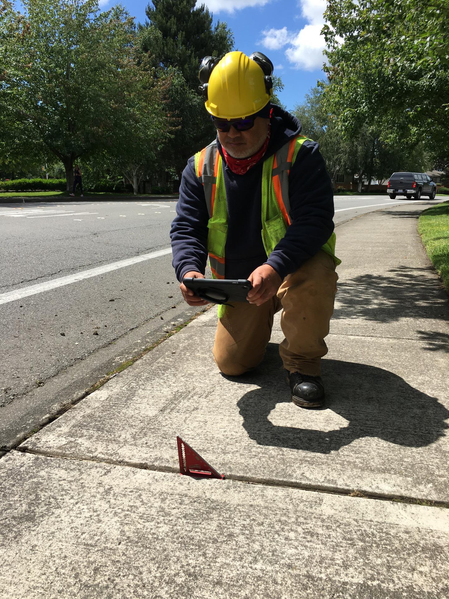 Staff taking photo during sidewalk inspection 