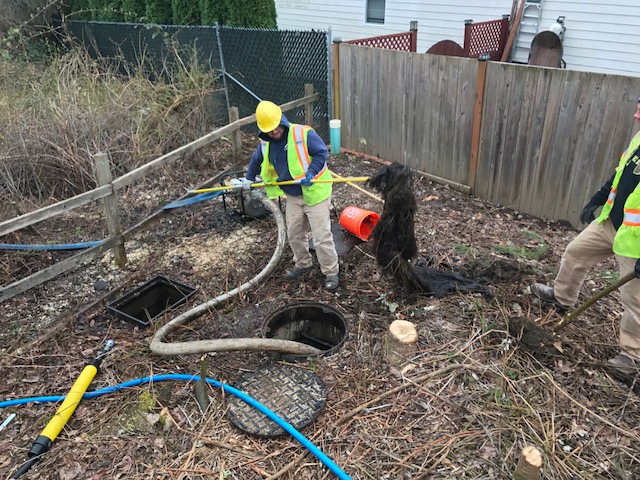 Staff removing blockage from storm pipe