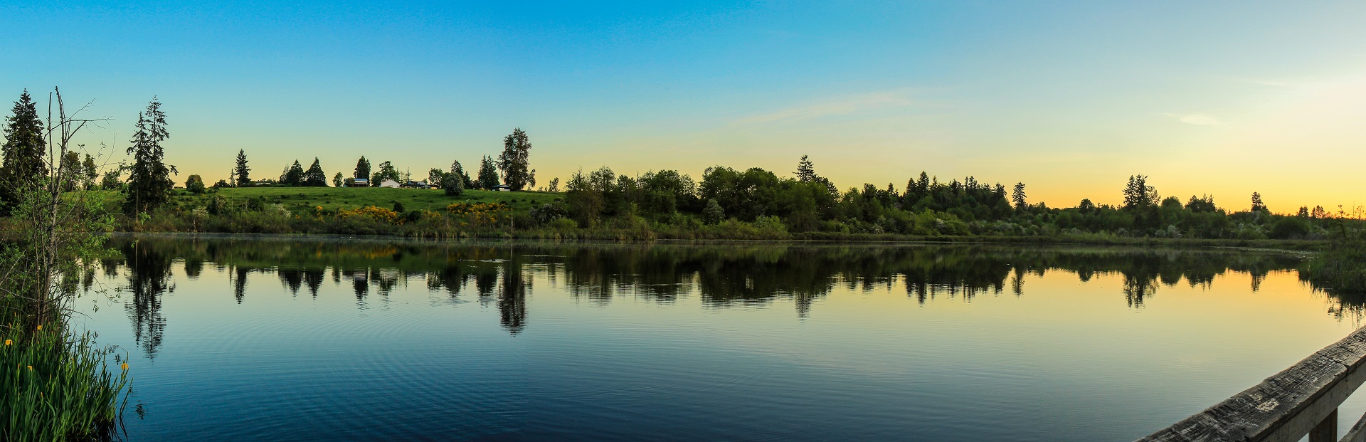 Sunrise over still waters of Clark Lake and clear blue sky