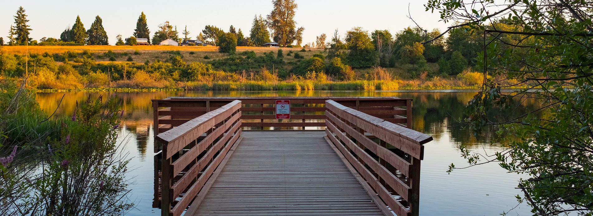 View of wood fishing pier with rails from the shore entry point