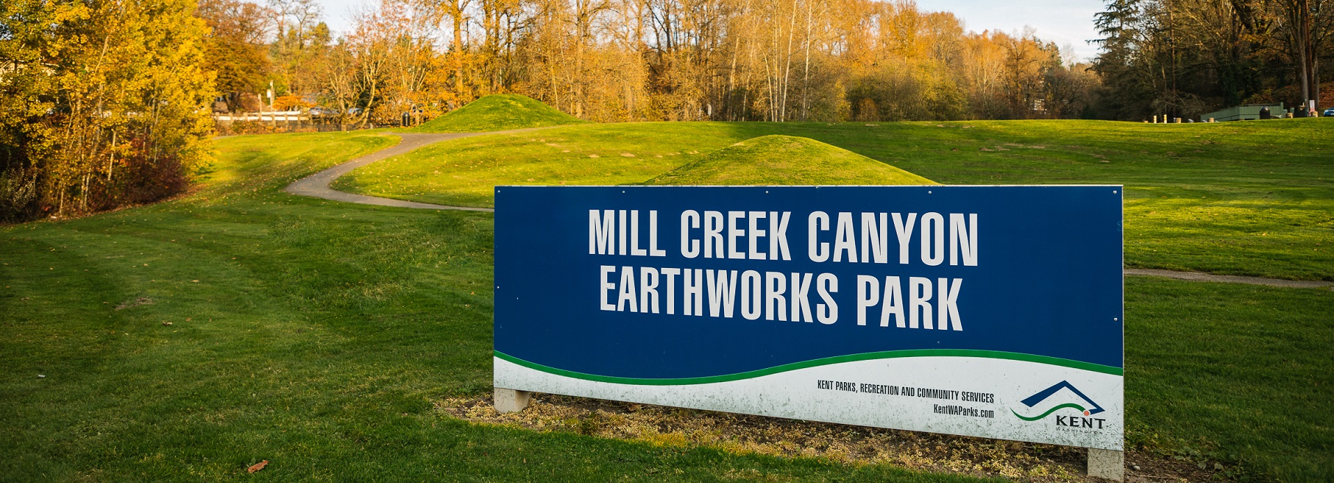 Ground-mounted, blue sign which says Mill Creek Canyon Earthworks Park