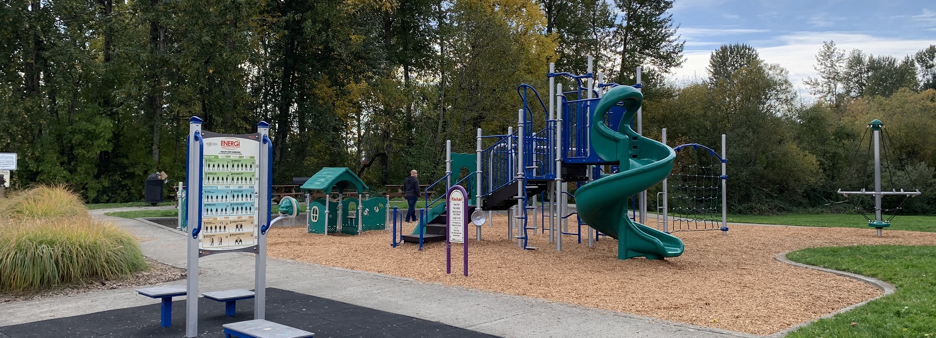 Blue and green play structure with a green spiral slide and green playhouse