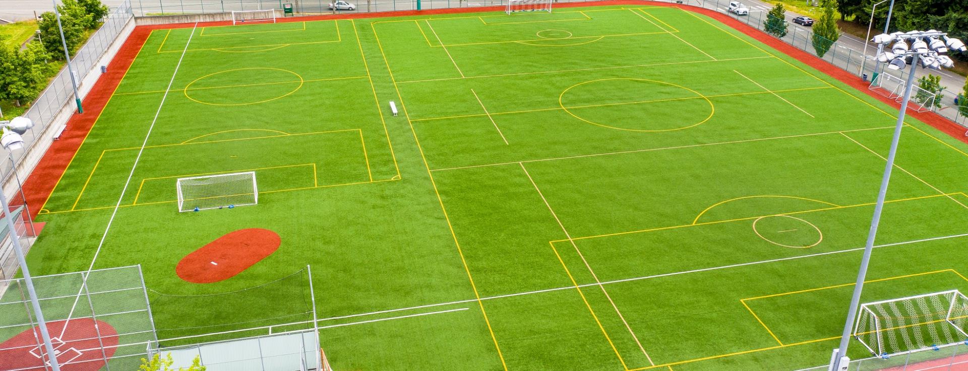 Aerial view of green artificial turf fields lined for multiple sports